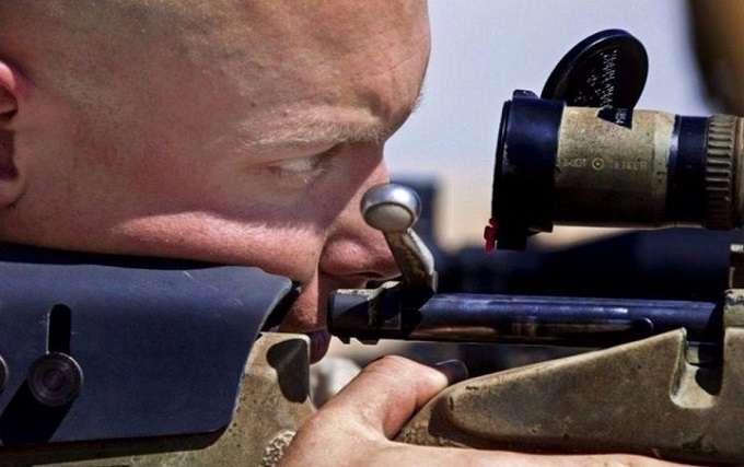 Man Looking Through Rifle Scope