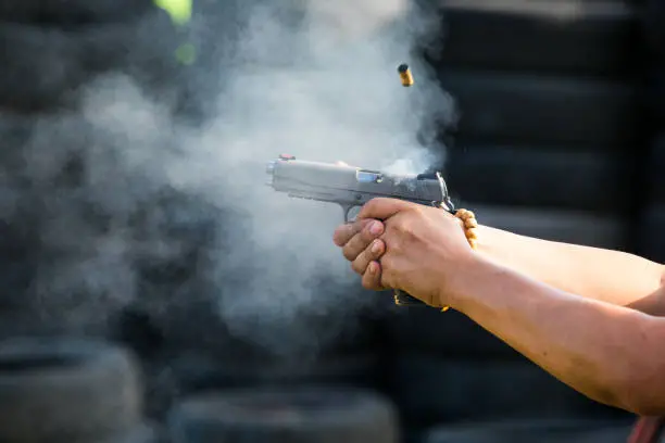 shooting a pistol handgun smoking